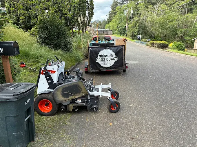 Coos Coast Cleanup crew with branded equipment trailer on a Coos County job site