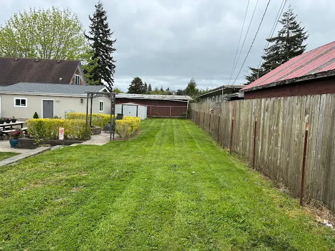 Maintained backyard lawn with fenced perimeter in Coos County